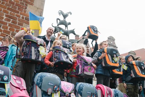 Ein kleines Stück Alltag: Auf dem Marktplatz von Bremen erhalten aus der Ukraine geflüchtete Jungen und Mädchen die mit Spendengeldern angeschafften Schulranzen der Stiftung stern und des Deutschen Kinderhilfswerks