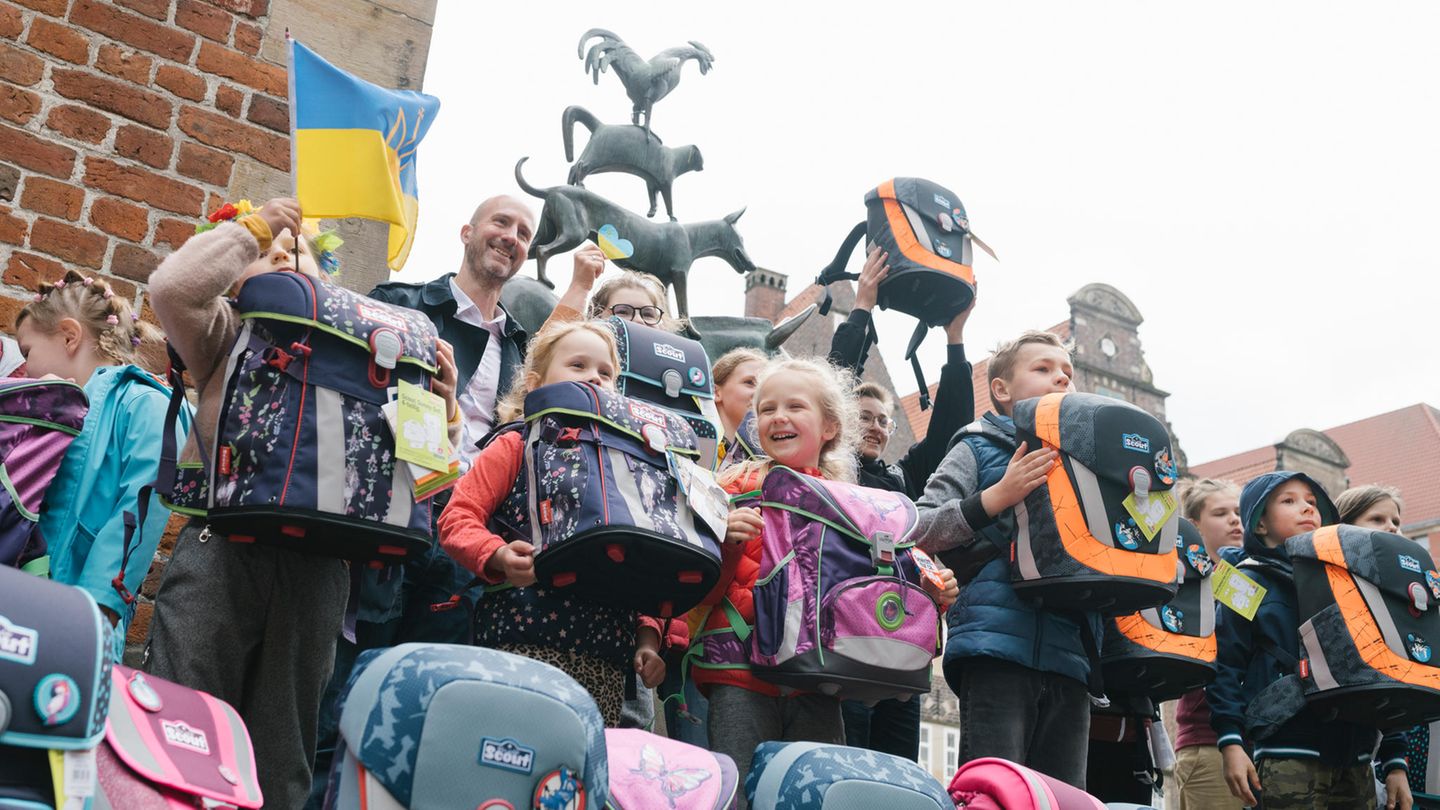 Ein kleines Stück Alltag: Auf dem Marktplatz von Bremen erhalten aus der Ukraine geflüchtete Jungen und Mädchen die mit Spendengeldern angeschafften Schulranzen der Stiftung stern und des Deutschen Kinderhilfswerks