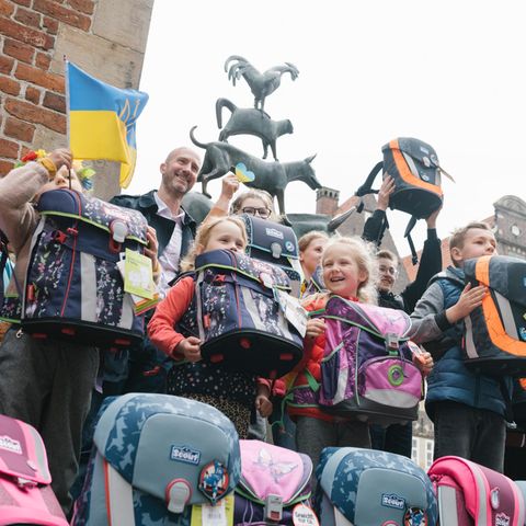 Ein kleines Stück Alltag: Auf dem Marktplatz von Bremen erhalten aus der Ukraine geflüchtete Jungen und Mädchen die mit Spendengeldern angeschafften Schulranzen der Stiftung stern und des Deutschen Kinderhilfswerks