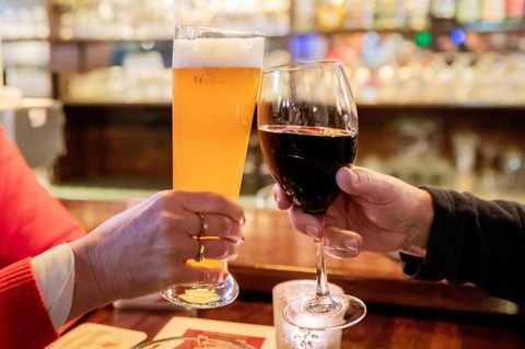 Zwei Gäste stoßen in einer Gaststätte mit Wein und Bier an. Laut Sucht-Jahresbericht ist Deutschland "Hochkonsumland".
