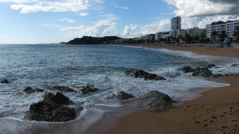 Grau Regenwolken über dem Strand von Lloret de Mar.