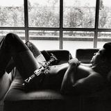 Muhammad Ali entsoannt mit einem Gewehr auf dem Schoß nach einem Boxkampf Training in Kinshasa