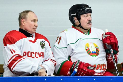 Wladimir Putin (l.) sitzt neben Alexander Lukaschenko während eines Spiels einer Eishockey-Mannschaft im Amateurbereich