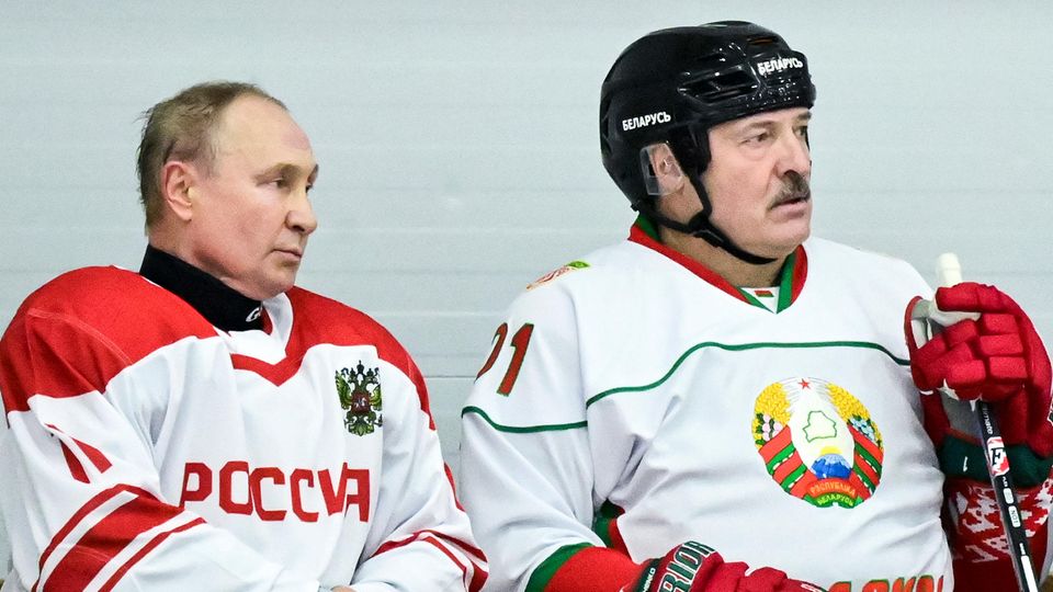 Wladimir Putin (l.) sitzt neben Alexander Lukaschenko während eines Spiels einer Eishockey-Mannschaft im Amateurbereich