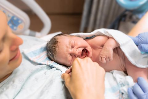 Neugeborenes Baby auf dem Arm der Mutter