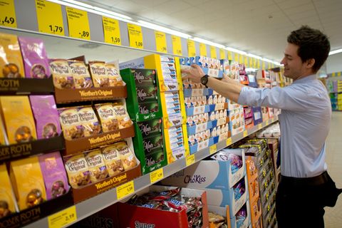 Aldi-Mitarbeiter räumt Regal ein