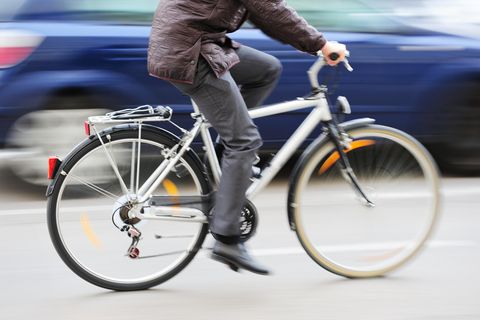 Fahrradfahrer fährt an Auto vorbei