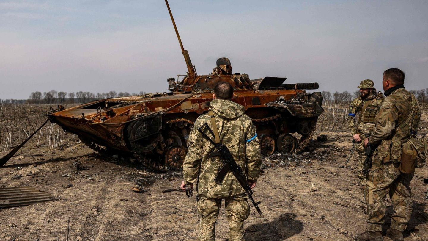 Soldaten der Ukraine begutachten am Rand von Kiew einen ausgebrannten russischen Panzer