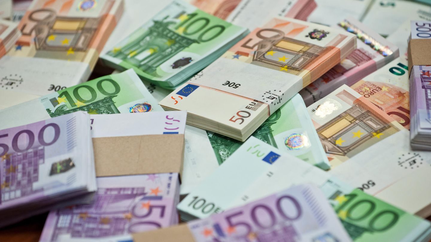 Mehrere Bündel mit Bargeld liegen neben- und aufeinander