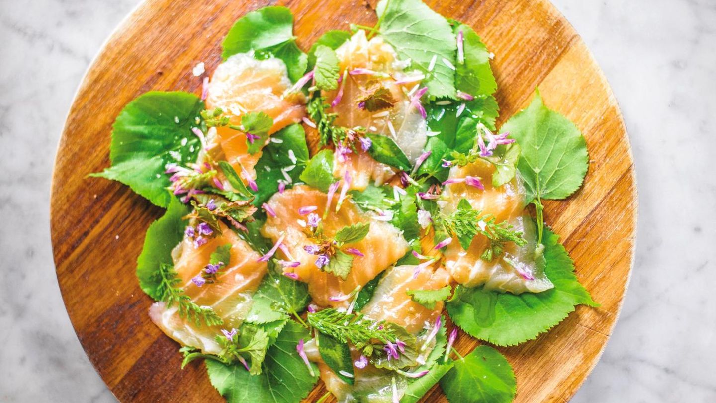 Sashimi vom Ostseelachs mit Lindenblättern      Zutaten:  Für 4 Personen  400 g Ostseelachsfilet ohne Haut, 2 EL helle Sojasauce, Saft von 1 Limette, 1 TL geröstetes Sesamöl, 2 Lindenblätter, ein paar essbare Blüten, z.B. Taubnessel oder Schafgarbe      Zubereitung:  1. Den Lachs mit einem sehr scharfen Messer in hauchdünne Scheiben schneiden.  2. Die Sojasauce mit dem Limettensaft und dem Sesamöl vermengen und mit einem Pinsel dünn auf die Lachstranchen auftragen.  3. Sashimi auf den Lindenblättern anrichten, mit Blüten garniert servieren.