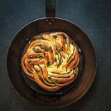 Bärlauchzopf      Zutaten:  Für 4 Personen als Beilage  75 g temperierte Butter, 265 g Mehl plus etwas Mehl zum Bestäuben, 10 g Zucker, 1 TL Trockenhefe, Abrieb von ½ Bio-Zitrone, 1 Ei, 1 Prise Salz, Öl zum Einfetten, 10 EL Bärlauchpesto, frisch geriebener Parmesan zum Bestreuen, ca. 20 Bärlauchblätter      Zubereitung:  1. Butter würfelig schneiden. Das Mehl mit Zucker, Hefe und Zitronenschale vermischen. Ei und 120 ml lauwarmes Wasser dazugeben. Bei niedriger Stufe für 3 Minuten verkneten, anschließend für weitere 3 Minuten bei mittlerer Stufe kneten. Salz und Butter nach und nach hinzugeben. Den Teig etwa 10 Minuten auf mittlerer Stufe zu einem glatten, elastischen Teig kneten.  2. Eine große Schüssel mit etwas Öl benetzen, den Teig hineingeben und abgedeckt über Nacht im Kühlschrank ruhen lassen.  3. Eine Form mit etwas Öl einfetten und den Boden mit Backpapier auslegen.  4. Den Teig auf der leicht bemehlten Arbeitsfläche zu einem ca. 40 x 30 cm großen Rechteck ausrollen und die Ränder begradigen. Das Bärlauchpesto gleichmäßig darauf verteilen. Dabei auf allen Seiten einen 2 cm breiten Rand frei lassen. Parmesan über das Pesto streuen und Bärlauch darauf verteilen.  5. Den Teig von der schmalen Seite her einrollen. Den frei gelassenen Rand mit etwas Wasser einstreichen und den Teig komplett einrollen, andrücken und mit der Naht nach unten legen. Die Enden der Rolle abschneiden. Die Rolle der Länge nach halbieren und die beiden Hälften zu einem Zopf flechten.  6. Den geformten Zopf in die vorbereitete Form geben, mit einem feuchten Tuch abdecken und abermals für 90 Minuten gehen lassen. 7 Im Backofen bei 190 °C ca. 30 Minuten backen.