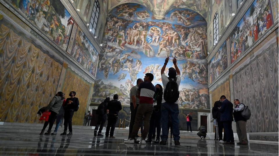 Sixtinische Kapelle Nachbildung Menschen stehen verstreut in einer sonst leeren Kirche mit bemalten Wänden und Decken