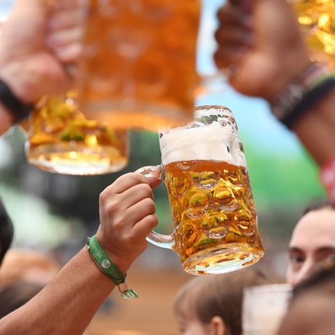 Besucher prosten sich beim Oktoberfest in einem Bierzelt zu