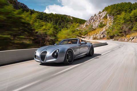 Der Roadster Wiesmann Thunderball fährt über eine Straße in einer bergigen Landschaft