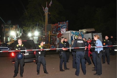 Polizeibeamte auf einem Platz hinter einem Absperrband