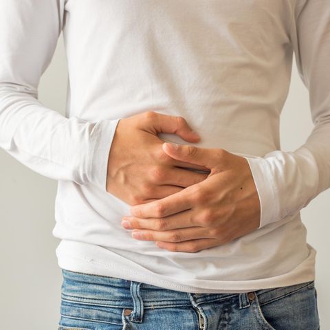 Mann hält sich an den Bauch