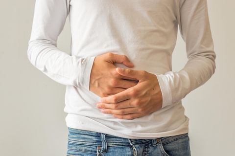 Mann hält sich an den Bauch