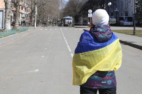Eine Frau mit ukrainischer Fahne während einer Demonstration gegen die russische Besatzung