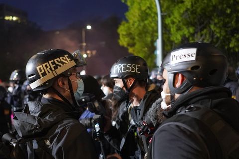 Fotojournalisten tragen bei einer Demonstration am 1. Mai  Helme mit der Aufschrift "Presse"
