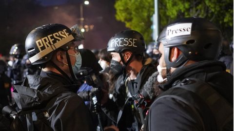 Fotojournalisten tragen bei einer Demonstration am 1. Mai  Helme mit der Aufschrift "Presse"