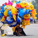 Ballonverkäuferin sucht Schutz vor der Sonne