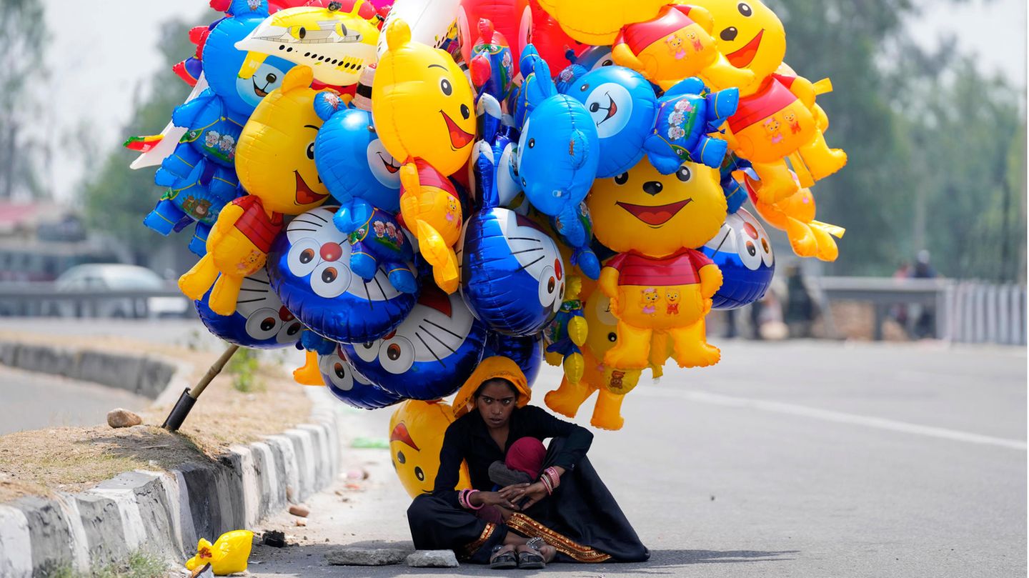 Ballonverkäuferin sucht Schutz vor der Sonne