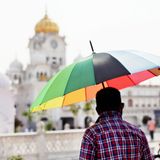 Anderswo sind die Aussichten trotz Hitze etwas schöner. Hier benutzt ein Mann seinen bunten Regenschirm als Sonnenschutz.