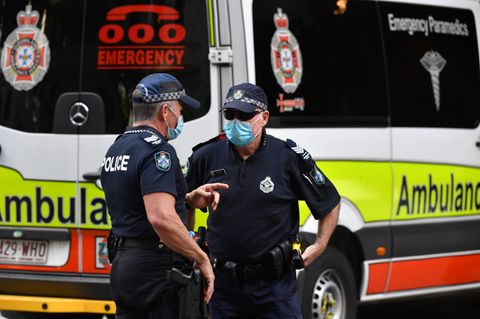 Polizisten stehen vor einem Krankenwagen in Australien