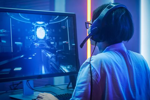 Ein Zocker sitzt vor einem 4K-Gaming-Monitor.