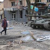 Frau vor Panzern in Mariupol