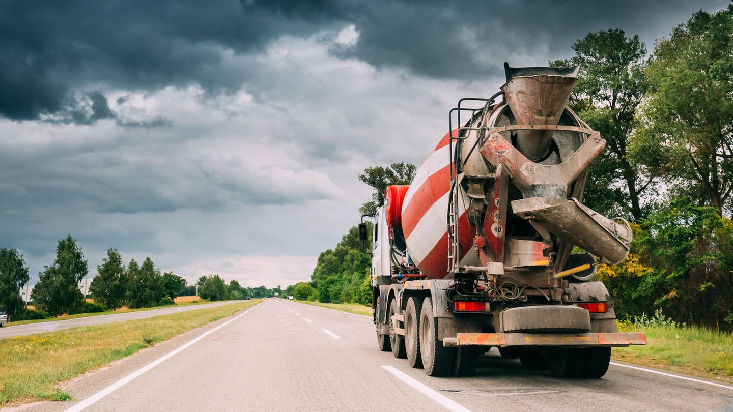 Ein Betonmischer fährt auf einer Landstraße. Ein Betonmischer fährt auf einer Landstraße.