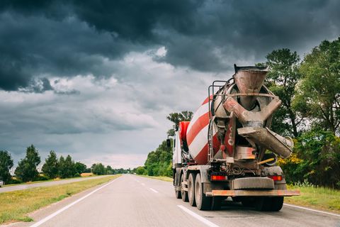 Ein Betonmischer fährt auf einer Landstraße.