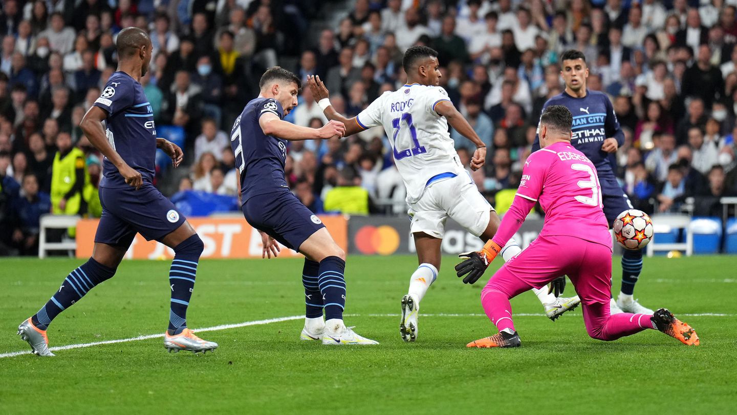 Champions League: So eine unfassbare Wende hat es in einem Champions-League-Spiel lange nicht gegeben. Manchester City liegt mit zwei Toren in Führung (das Hinspiel mit gerechnet), dann bricht die 90. Minute an. Real Madrid braucht zwei Treffer, um überhaupt die Verlängerung zu erreichen. Was folgt in das dritte Comeback seit dem Achtelfinale gegen PSG. Das Wunder tritt diesmal in Gestalt des Brasilianers Rodrygo (im Bild) auf, der zweimal innerhalb einer Minute zuschlägt. Mit 2:1 für die Spanier geht es in die Verlängerung, in der ... So eine unfassbare Wende hat es in einem Champions-League-Spiel lange nicht gegeben. Manchester City liegt mit zwei Toren in Führung (das Hinspiel mit gerechnet), dann bricht die 90. Minute an. Real Madrid braucht zwei Treffer, um überhaupt die Verlängerung zu erreichen. Was folgt in das dritte Comeback seit dem Achtelfinale gegen PSG. Das Wunder tritt diesmal in Gestalt des Brasilianers Rodrygo (im Bild) auf, der zweimal innerhalb einer Minute zuschlägt. Mit 2:1 für die Spanier geht es in die Verlängerung, in der ...