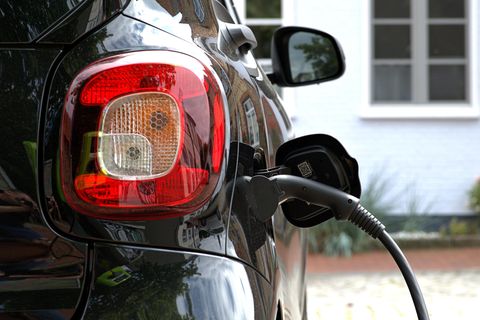 Ein Stromkabel ist an einem Elektroauto angeschlossen