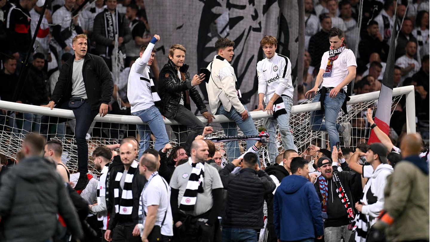 Die Fans setzen sich auf die Torlatte, die das Gewicht offenbar so gerade hält.