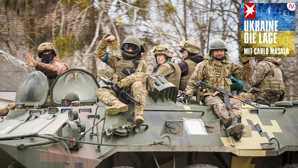 Ukraine, Hostomel: Ukrainische Truppen sitzen auf einem Militärfahrzeug