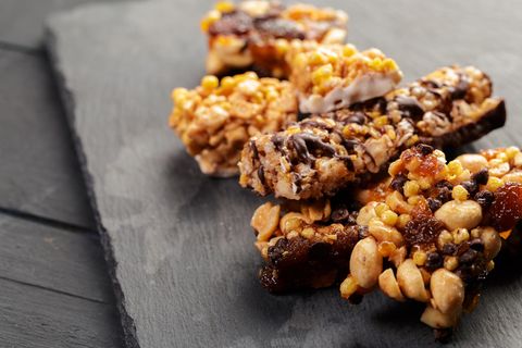 Gesunde Snacks zum Abnehmen: Müsliriegel mit Schokolade und Früchten auf einer grauen Platte