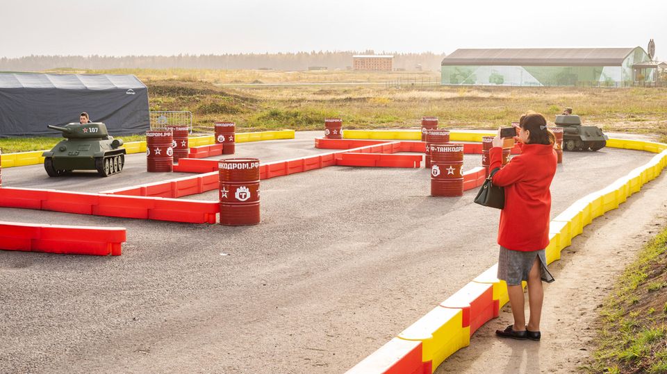 Eine Mutter fotografiert ihren Sohn in einem Mini-Panzer im "Tankodrome" Eine Mutter fotografiert ihren Sohn in einem Mini-Panzer im "Tankodrome"
