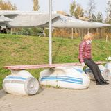 Eine Frau sitzt auf einer Bank in Flugzeugform