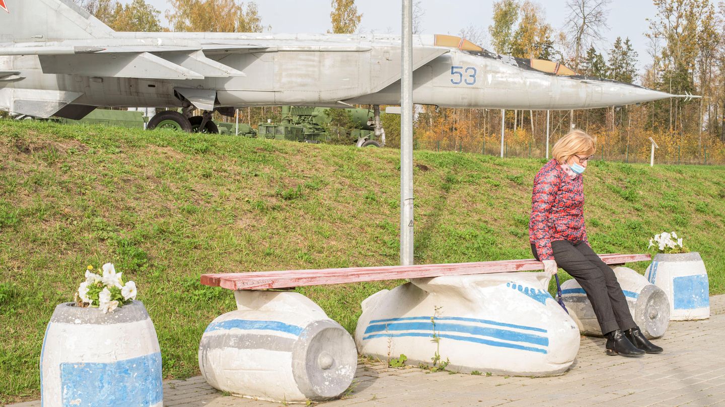 Eine Frau sitzt auf einer Bank in Flugzeugform