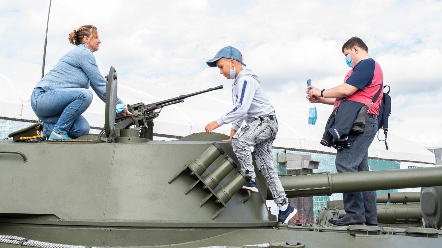 Eine Familie posiert auf einem Panzer