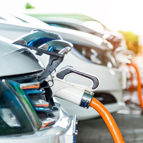 Mehrere Elektroautos parken an Ladesäulen um ihre Batterien aufzuladen