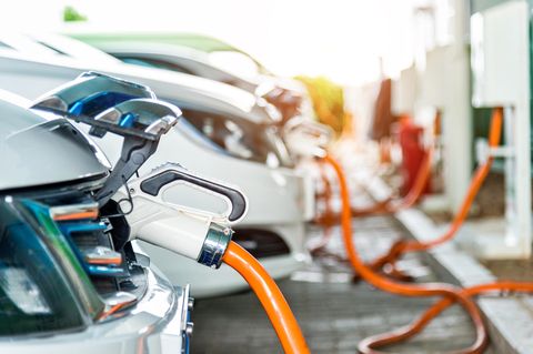 Mehrere Elektroautos parken an Ladesäulen um ihre Batterien aufzuladen