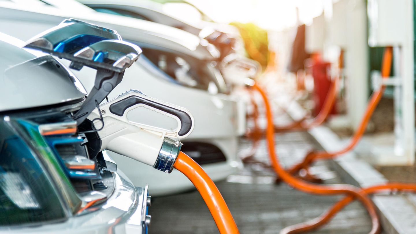 Mehrere Elektroautos parken an Ladesäulen um ihre Batterien aufzuladen