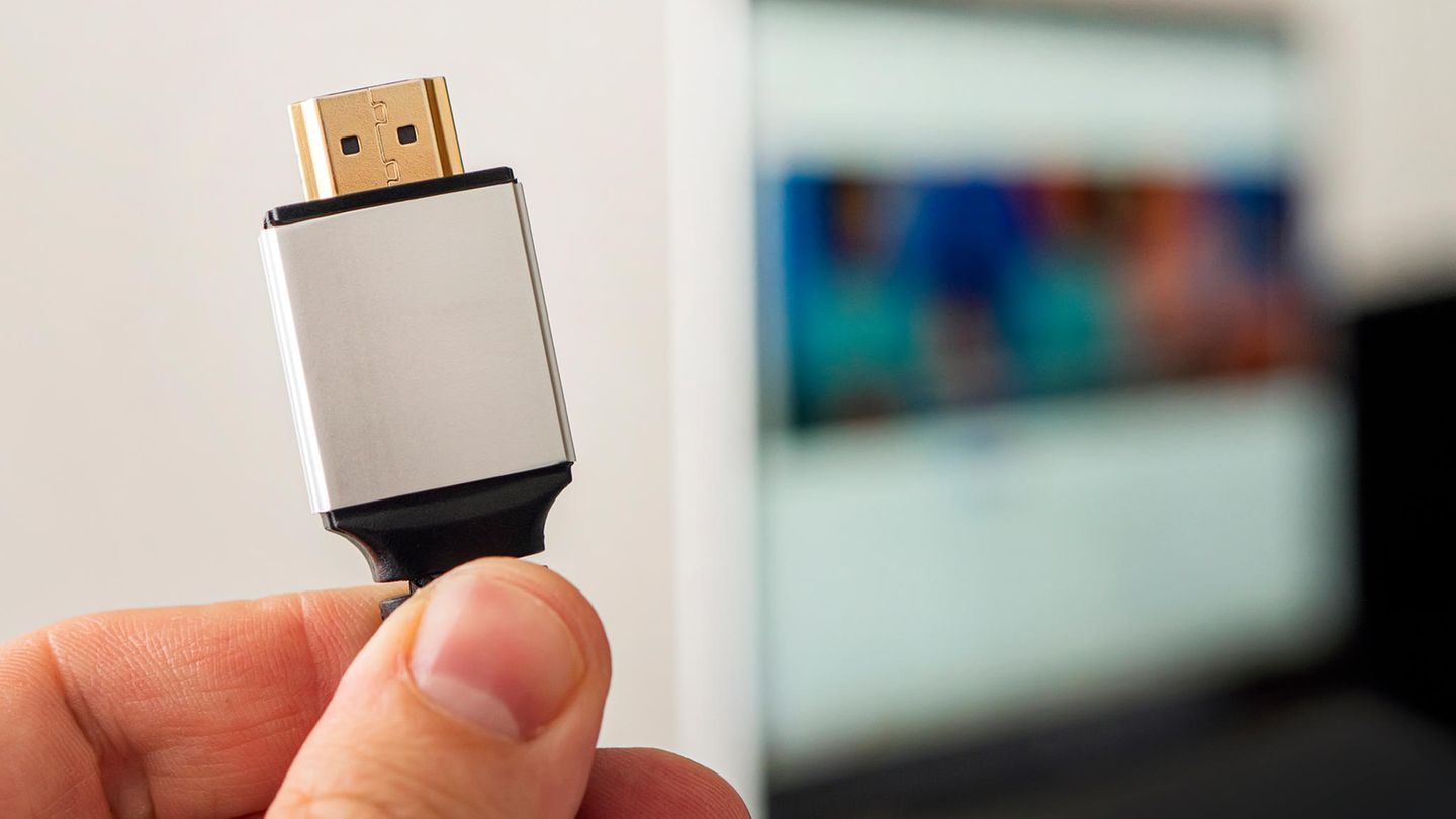 HDMI Kabel Unterschiede: Eine Hand hält ein HDMI-Kabel in die Luft.