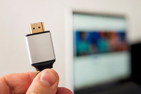 HDMI Kabel Unterschiede: Eine Hand hält ein HDMI-Kabel in die Luft.