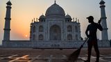 Agra, Indien. Ein Arbeiter fegt den Platz vor dem Taj Mahal, während im Hintergrund die Sonne aufgeht. Maharaja Sha Jahan hatte die Grabmoschee einst errichten lassen, als Andenken an seine große Liebe, Mumtaz Mahal, die im Jahr 1631 bei der Geburt des 14. Kindes verstarb. Das Taj Mahal zählt zu den sieben Weltwundern und gehört seit 1983 zum Weltkulturerbe der Unesco.