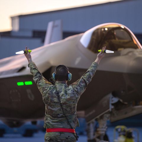 Ein Crew Chief der U.S. Air Force der 158th Fighter Wing gibt einem F-35A Lightning II-Kampfflugzeug Zeichen