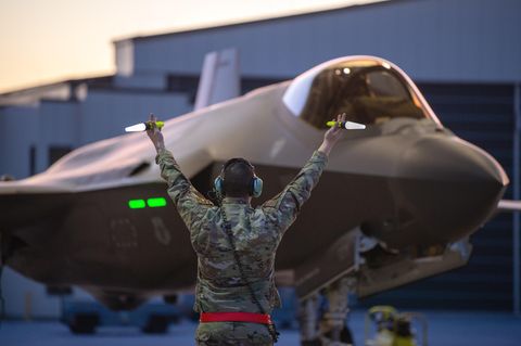 Ein Crew Chief der U.S. Air Force der 158th Fighter Wing gibt einem F-35A Lightning II-Kampfflugzeug Zeichen