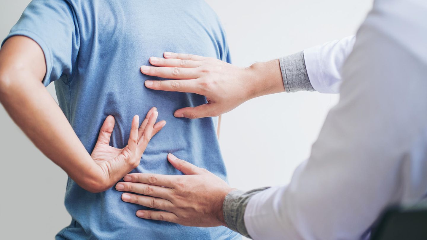 Ein Arzt untersucht den Rücken einer Patientin